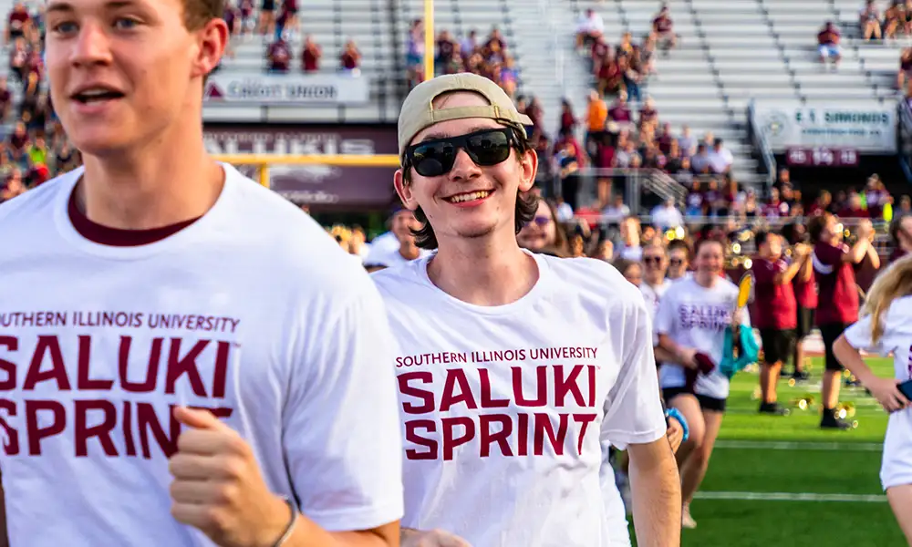 Students running across the field during the Saluki Sprint at SIU.
