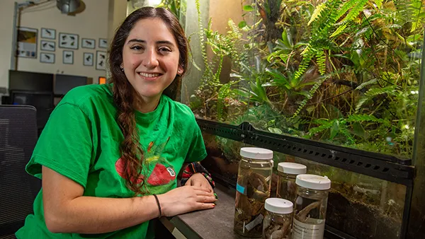 Student with specimen jars and terrarium.