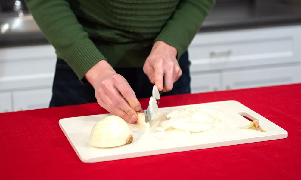 A person slices onions.