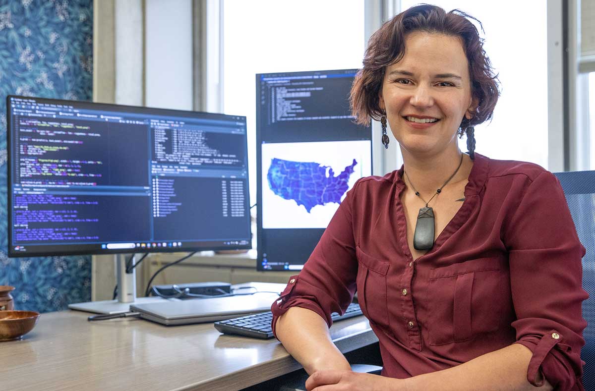 A professor poses near her computer.