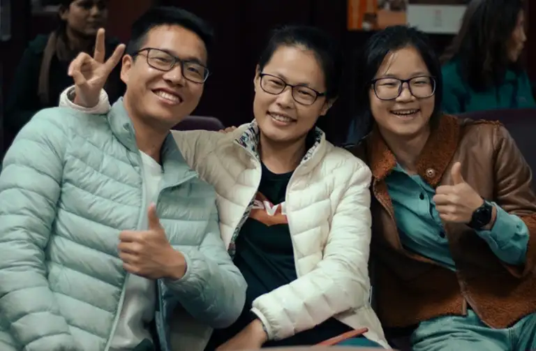 Students giving thumbs up and smiling during an international student gathering at Southern Illinois University.